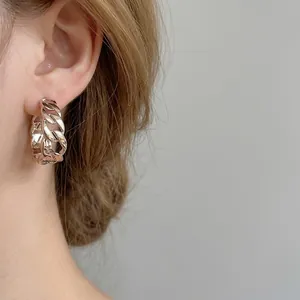 Eleganti orecchini a cerchio a catena metallica dorata per donna, vista indossata