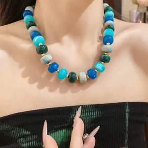Detailed close-up of a chunky handmade geometric beaded necklace in vibrant blue and green