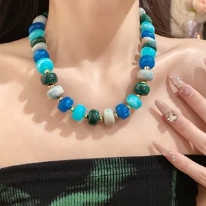 Close-up of a chunky geometric beaded necklace with blue and green marbled beads.
