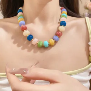 Close-up detail of a colorful handmade geometric beaded necklace worn by a model