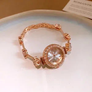 Elegante roségoldene Damenuhr mit Blumenarmband und glitzernder Kristalllünette.