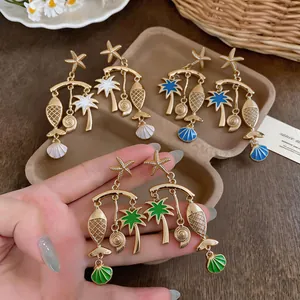 Gold-plated holiday dangle earrings featuring beach motifs like fish, starfish, and palm trees.