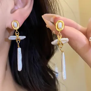 Close-up of vintage gold-plated drop earrings with white freshwater stick pearls