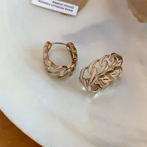 Primo piano dettagliato di orecchini a cerchio a catena dorata con elegante design cavo