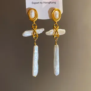 Vintage-style gold earrings with natural baroque and oval pearls on white display card.