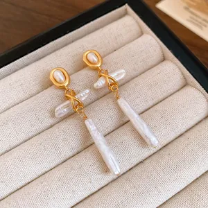 Detail shot of vintage gold drop earrings featuring unique natural freshwater pearls