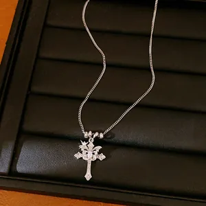 Silver double cross necklace with zircon star pendant displayed on a black jewelry tray.