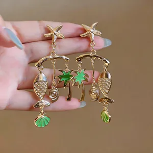 Detailed view of beach-themed earrings with green enamel fish and starfish charms