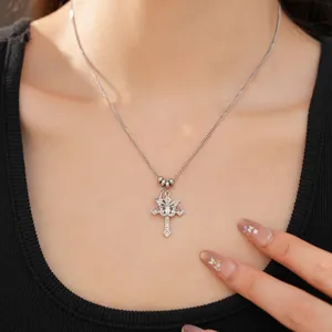 Close-up of a stylish silver double cross necklace with zircon worn by a model
