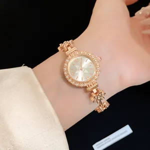 Nahaufnahme einer roségoldenen Uhr mit Blumen-Herz-Armband und funkelnden Kristallen