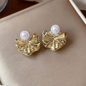 Eleganti orecchini a perno dorati con perla e zircone in un design a fiore pieghettato