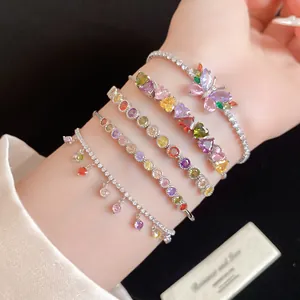 Vue macro de bracelets luxueux en zircone colorée avec breloques papillon et cœur