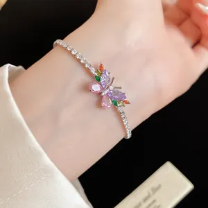Vue macro d'un élégant papillon en zircon coloré sur un bracelet en argent délicat