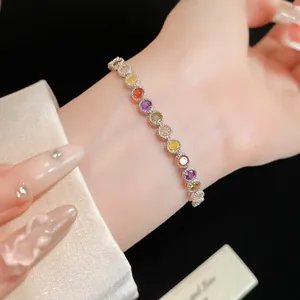 Détail macro d'un bracelet de tennis en zircon rond coloré sur un poignet élégant