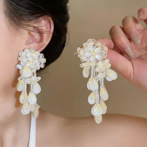Close-up view of elegant pearlescent flower tassel earrings featuring delicate shimmering petal drops