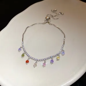 Gros plan d'un bracelet en argent avec des pendentifs en zircone ronde multicolore vibrante