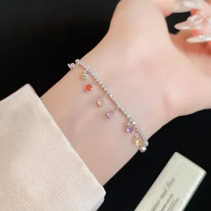 Gros plan d'un bracelet en zircon avec des pendentifs ronds colorés sur un poignet