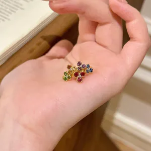 Detailed view of a gold flower bracelet featuring vibrant multi-color gemstones