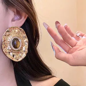 Vintage baroque style golden oval stud earrings featuring dark stone and clear rhinestones