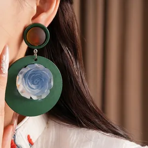 Large vintage green round resin drop earrings featuring a delicate blue rose flower center