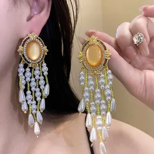Elegante vergoldete Tropfenohrringe mit Katzenaugenstein und langen weißen Perlenquasten
