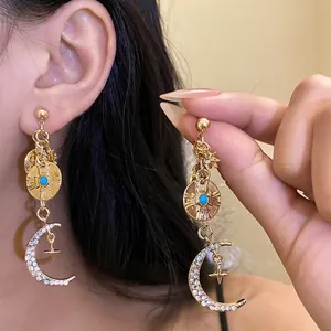 Élégantes boucles d'oreilles lune et étoile dorées avec pierre bleue et cristaux