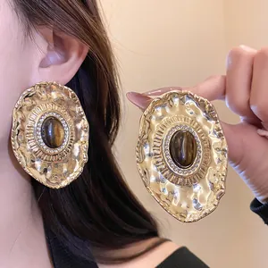 Detail view of vintage gold hammered oval earrings with resin center and rhinestones