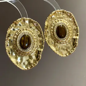 Close-up of vintage gold hammered oval earrings with brown resin and crystals