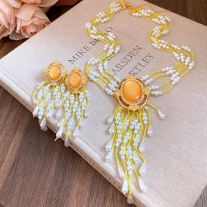 Detailansicht von luxuriösem Perlen- und Steinschmuckset mit eleganten Fransenquasten