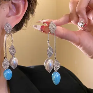 Vintage silver needle earrings with rhinestone leaf design and blue/white drop pendants