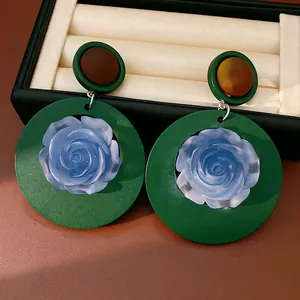 Retro resin drop earrings featuring blue rose centers on green circular frames for women.
