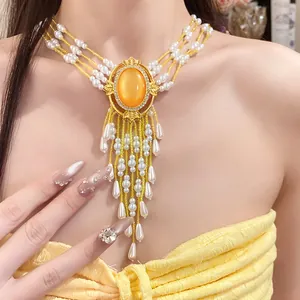 Detailansicht eines luxuriösen Perlen-Chokers mit orangefarbenem Edelstein und Perlen.