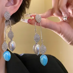 Detailed close-up showing vintage court-style silver needle earrings with rhinestones and leaves