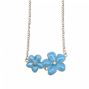 Elegant silver-tone vintage necklace featuring dual blue enamel flower pendants