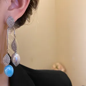 Detailed view of elegant vintage rhinestone leaf dangle earrings with blue and white beads
