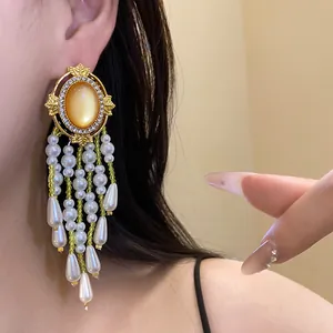 Exquisite Nahaufnahme von goldenen Vintage-Ohrringen mit Perlenquasten und Kristallakzenten