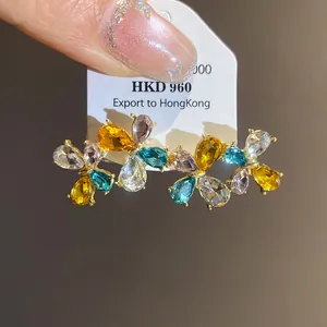Detailed view of colorful flower-shaped earrings featuring vibrant zirconia crystals and gold plating