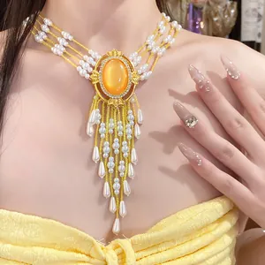 Detailansicht eines luxuriösen Perlen-Chokers mit orangefarbenem Edelsteinanhänger