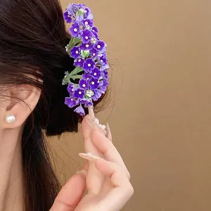 Close-up of elegant purple floral hairpin styled in hair for a gentle, romantic look