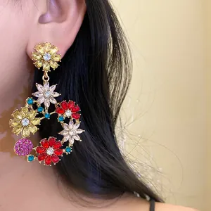Close-up of French vintage gold earrings with colorful zircon floral design on ear