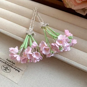 Detail of elegant pink flower hairpins with green stems in a spring garden style