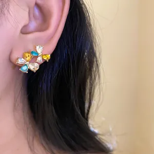 Detailed view of elegant colorful zircon flower stud earrings on an Asian model ear
