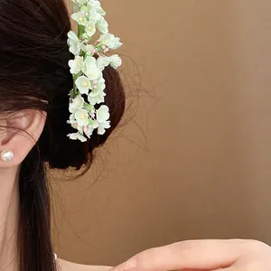 Detail shot of a delicate floral hairpin worn in dark hair, elegant spring accessory
