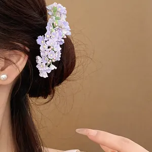 Close-up detail of a delicate lavender floral hair pin worn in a romantic updo hairstyle