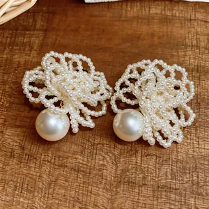 Detailed macro view of handcrafted white beaded flower earrings with large pearls