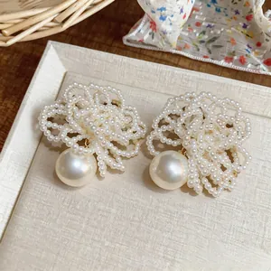 Detail shot of handmade beaded flower pearl stud earrings with elegant silver needle.