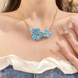 Elegant blue enamel flower necklace worn by a model showcasing retro gold chain details