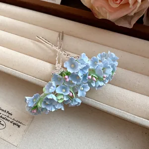 Detail view of delicate light blue floral hairpins in a vintage jewelry tray.