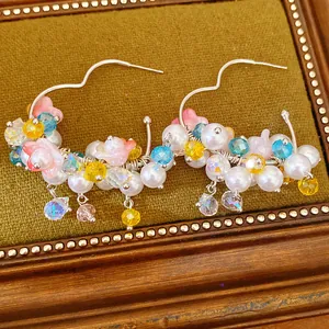 Nahaufnahme von bunten Creolen mit floralen Perlen und Kristallen
