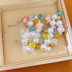 Detaillierte Nahaufnahme bunter Blumen-Ohrringe mit weißen Perlen und geschliffenen Kristallen